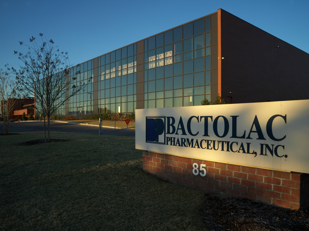 Exterior view of bactolac pharmaceutical, inc. building with large glass facade; company sign in foreground.